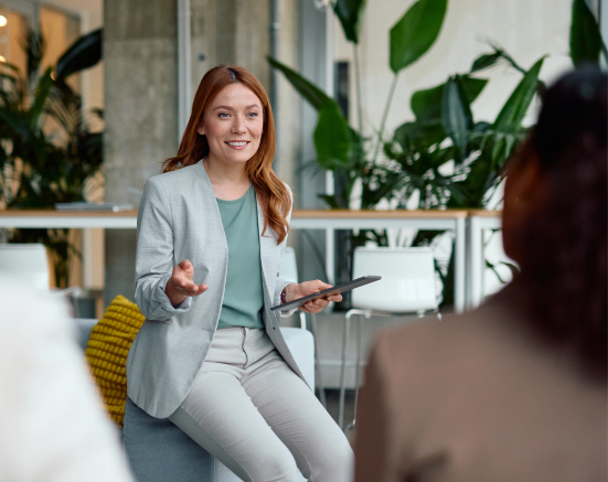 Businesswoman seated and presenting to her team