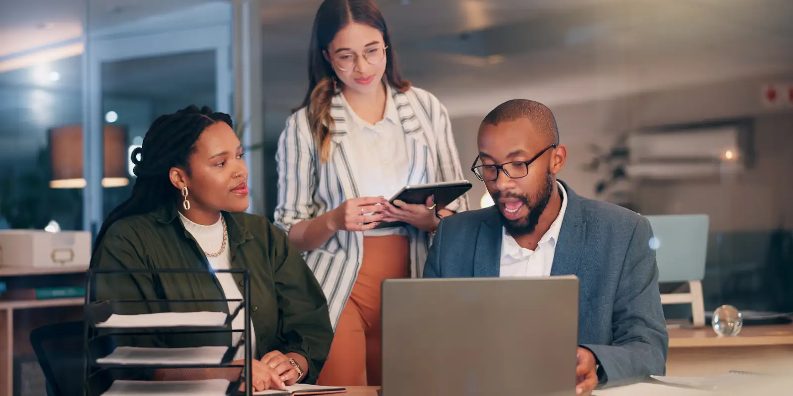 People at a conference room table looking at AI SEO data on a laptop