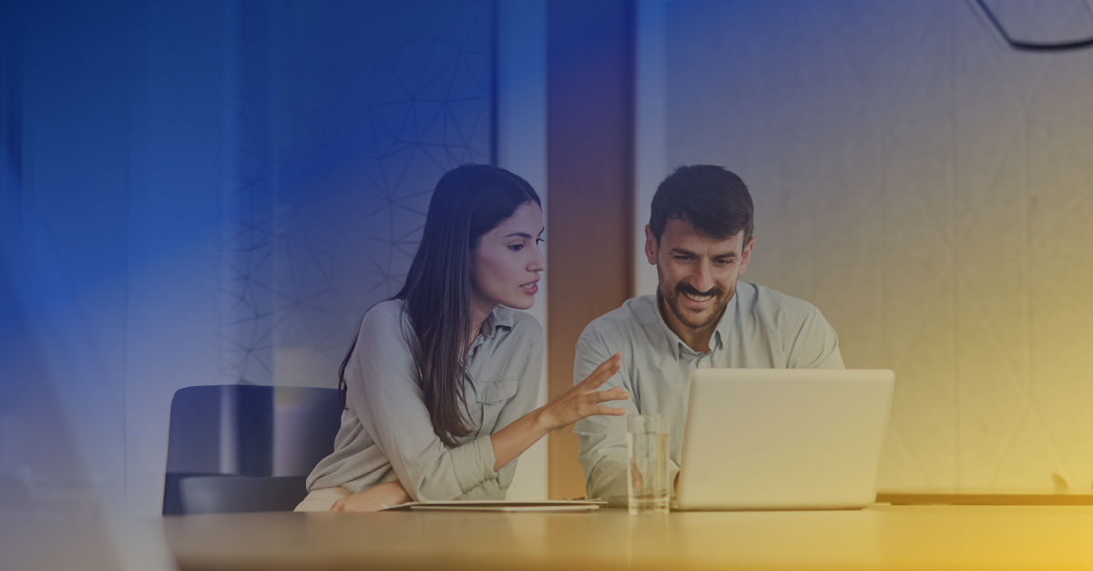 Two salespeople reviewing information on a laptop